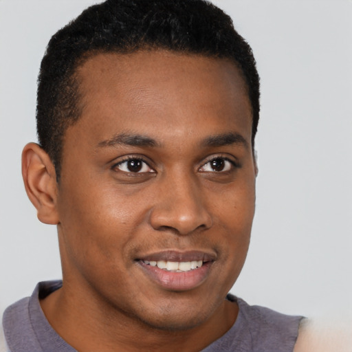 Joyful black young-adult male with short  brown hair and brown eyes