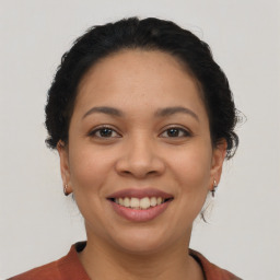 Joyful latino young-adult female with medium  brown hair and brown eyes