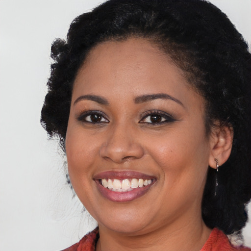 Joyful black young-adult female with long  black hair and brown eyes