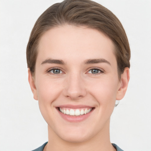 Joyful white young-adult female with short  brown hair and grey eyes