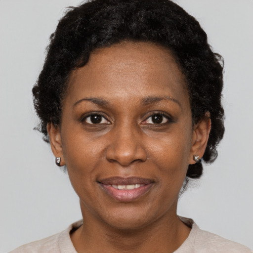Joyful black adult female with short  black hair and brown eyes