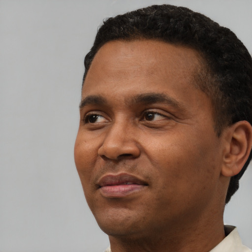 Joyful black adult male with short  black hair and brown eyes