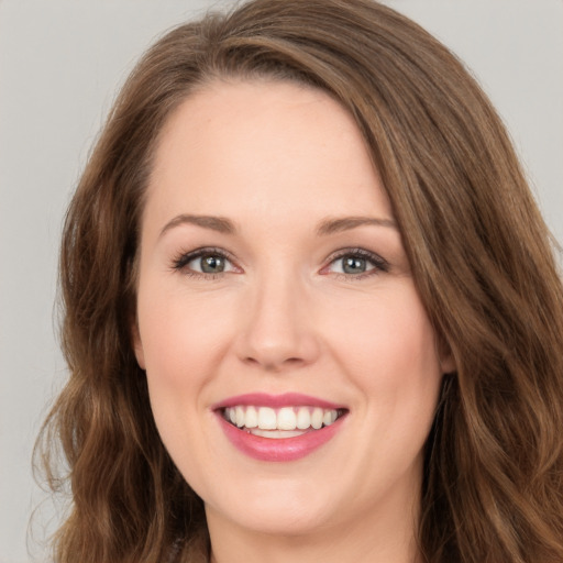 Joyful white young-adult female with long  brown hair and green eyes