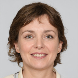 Joyful white adult female with medium  brown hair and grey eyes