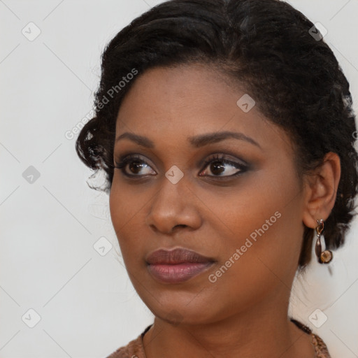 Joyful black young-adult female with long  brown hair and brown eyes