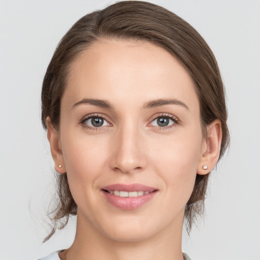 Joyful white young-adult female with medium  brown hair and grey eyes