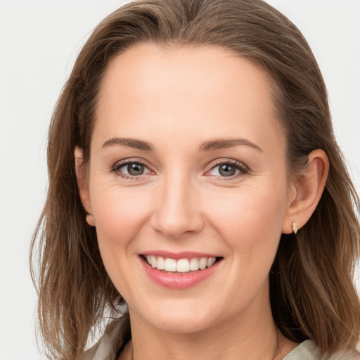 Joyful white young-adult female with long  brown hair and grey eyes