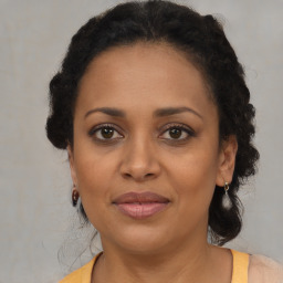 Joyful black adult female with medium  brown hair and brown eyes