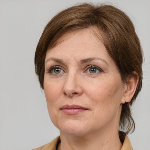 Joyful white adult female with medium  brown hair and grey eyes