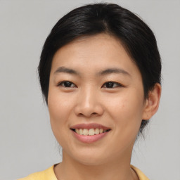 Joyful asian young-adult female with short  brown hair and brown eyes