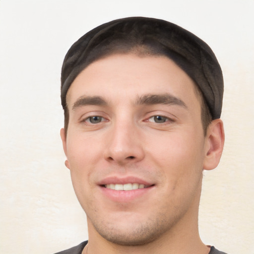 Joyful white young-adult male with short  black hair and brown eyes