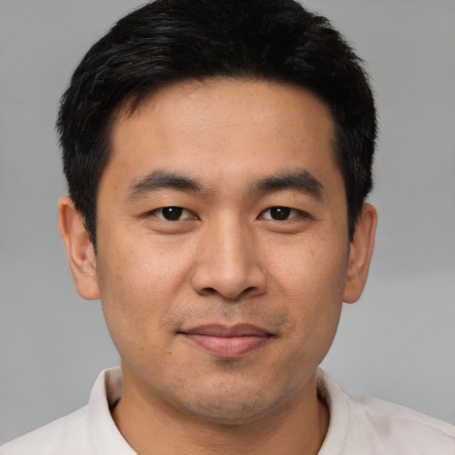 Joyful asian young-adult male with short  black hair and brown eyes