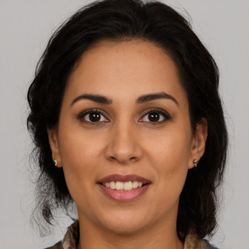 Joyful latino young-adult female with medium  brown hair and brown eyes