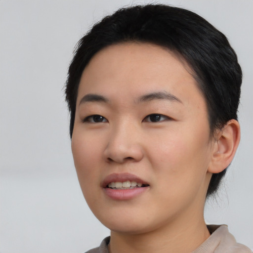 Joyful asian young-adult female with short  black hair and brown eyes