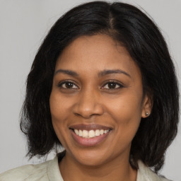 Joyful black young-adult female with medium  brown hair and brown eyes