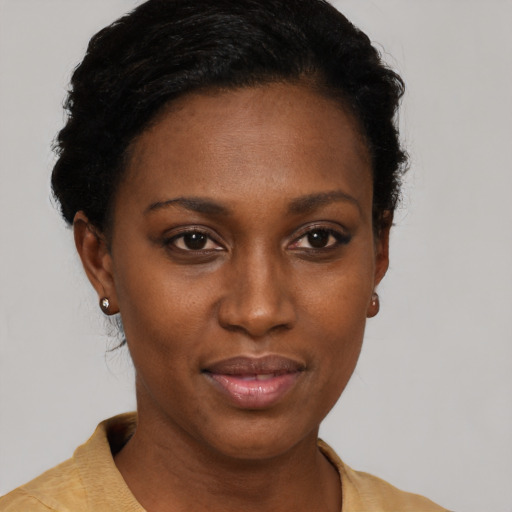 Joyful black young-adult female with short  black hair and brown eyes