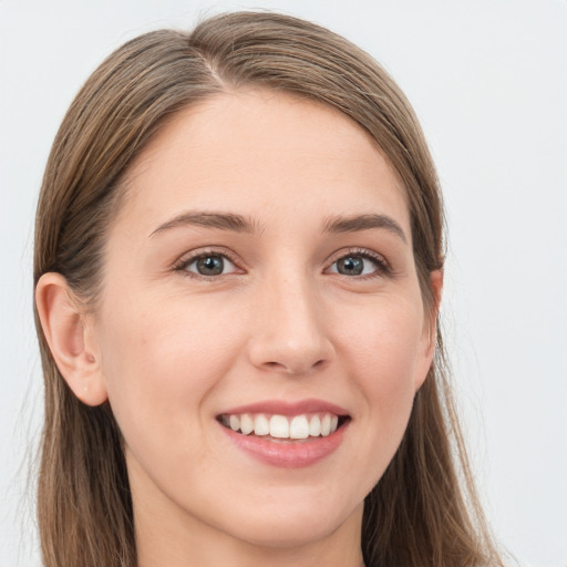 Joyful white young-adult female with long  brown hair and blue eyes