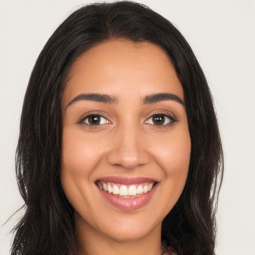 Joyful latino young-adult female with long  brown hair and brown eyes