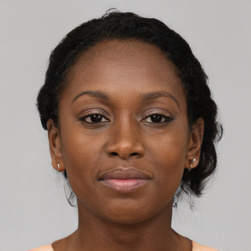 Joyful black young-adult female with long  brown hair and brown eyes