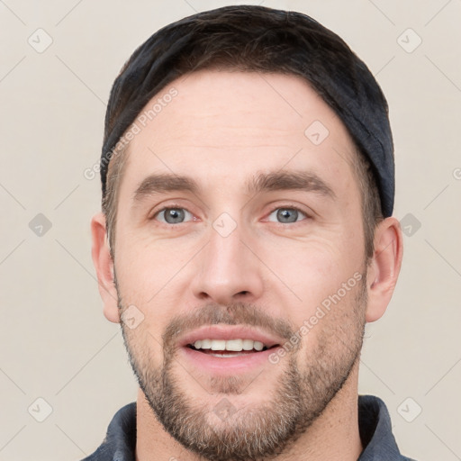 Joyful white young-adult male with short  black hair and brown eyes