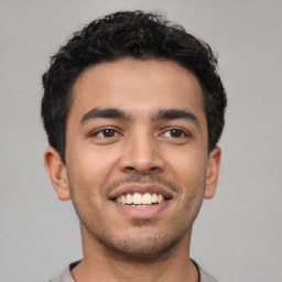 Joyful latino young-adult male with short  brown hair and brown eyes