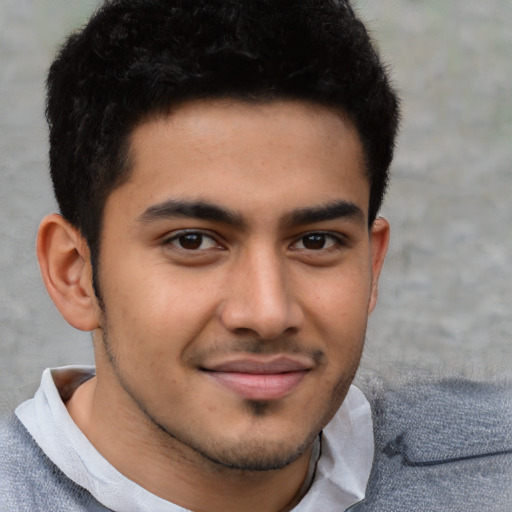 Joyful latino young-adult male with short  brown hair and brown eyes