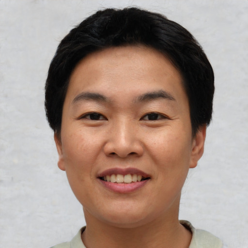 Joyful asian young-adult female with short  black hair and brown eyes