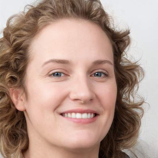 Joyful white young-adult female with medium  brown hair and blue eyes