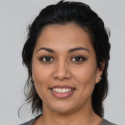 Joyful latino young-adult female with medium  brown hair and brown eyes