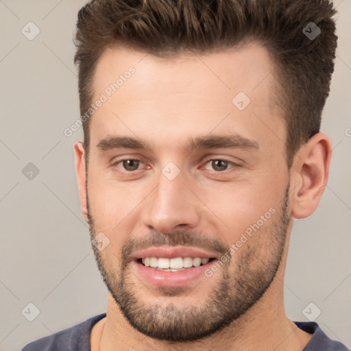 Joyful white young-adult male with short  brown hair and brown eyes