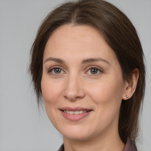 Joyful white adult female with medium  brown hair and brown eyes