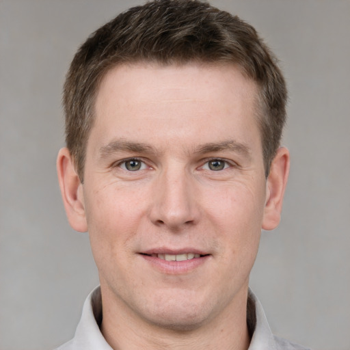 Joyful white adult male with short  brown hair and grey eyes