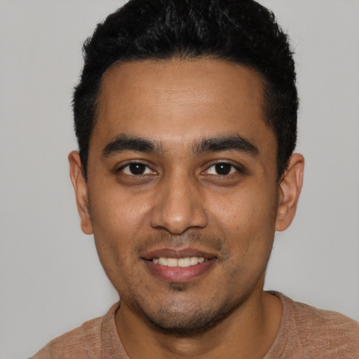 Joyful latino young-adult male with short  black hair and brown eyes