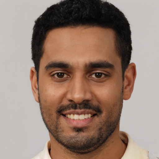 Joyful latino young-adult male with short  black hair and brown eyes