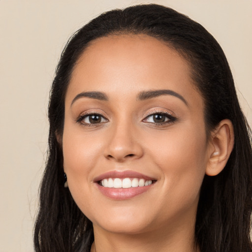 Joyful latino young-adult female with long  brown hair and brown eyes