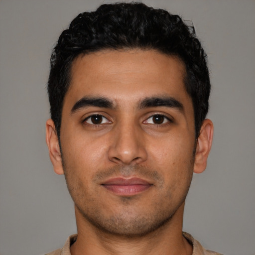 Joyful latino young-adult male with short  black hair and brown eyes