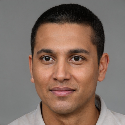 Joyful latino adult male with short  brown hair and brown eyes