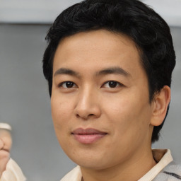 Joyful asian young-adult male with short  black hair and brown eyes