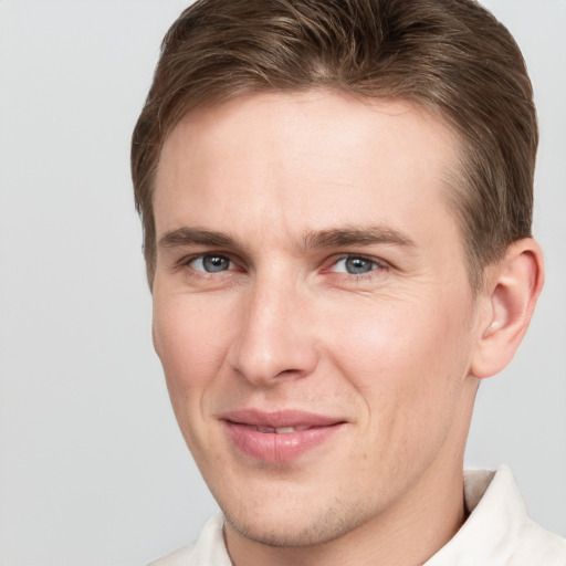 Joyful white young-adult male with short  brown hair and grey eyes