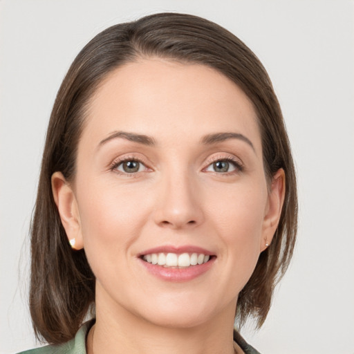 Joyful white young-adult female with medium  brown hair and grey eyes