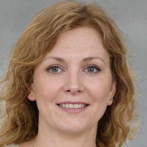 Joyful white adult female with medium  brown hair and green eyes