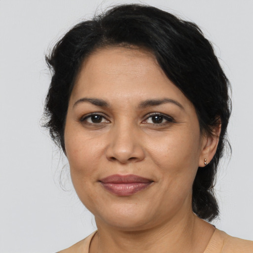 Joyful latino adult female with medium  brown hair and brown eyes