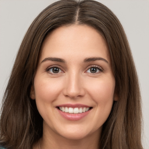 Joyful white young-adult female with long  brown hair and brown eyes