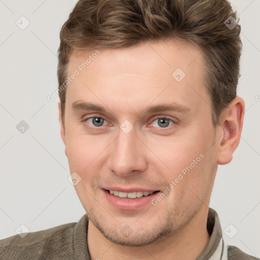 Joyful white young-adult male with short  brown hair and grey eyes