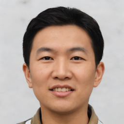 Joyful asian young-adult male with short  black hair and brown eyes