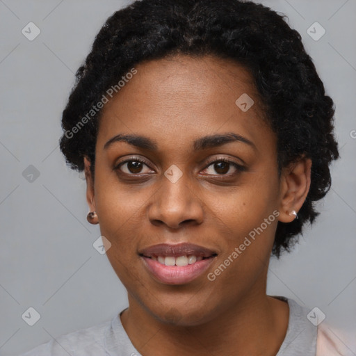 Joyful black young-adult female with short  black hair and brown eyes