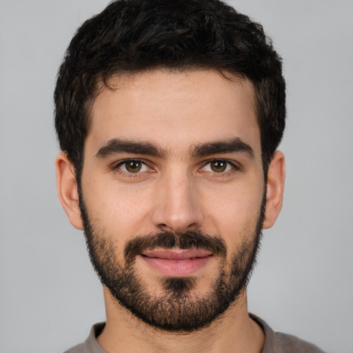 Joyful white young-adult male with short  black hair and brown eyes