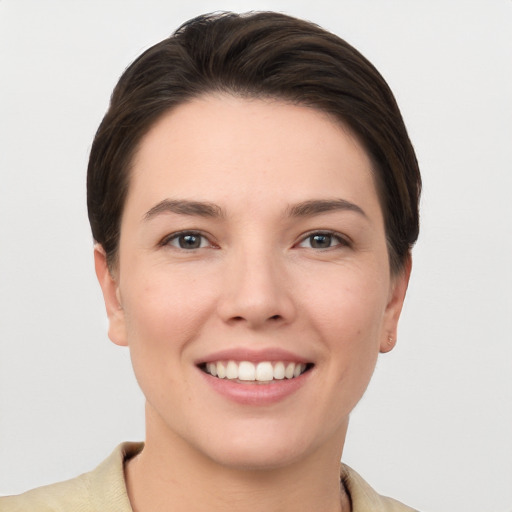 Joyful white young-adult female with short  brown hair and grey eyes