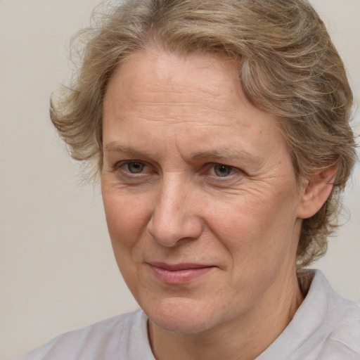 Joyful white middle-aged female with medium  brown hair and blue eyes