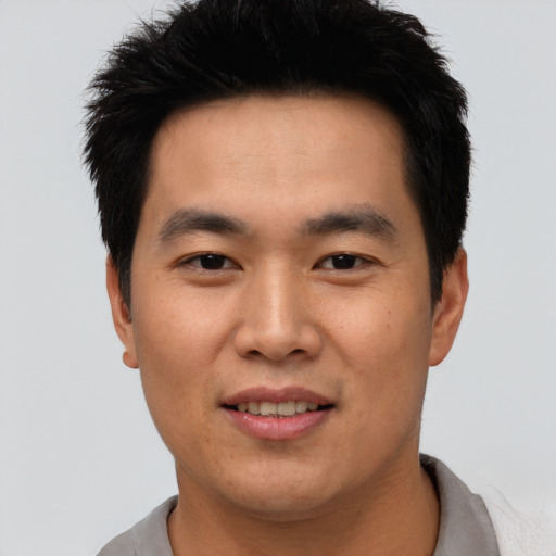 Joyful asian young-adult male with short  black hair and brown eyes